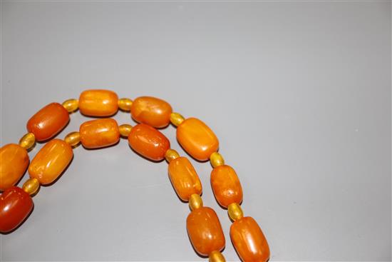 A single strand barrel shaped amber bead necklace, 124cm, gross weight 75 grams.